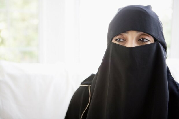Frau trägt Burka vor einem hellen Hintergrund