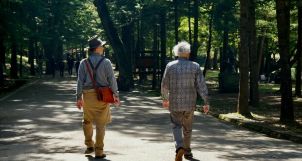 Mit zunehmendem Alter sinkt die Knochengesundheit. Spaziergänge und leichter Sport können helfen. Zwei ältere Manner gehen spazieren. Bild: unsplash_beth-macdonald-yh_ScmcPQeI
