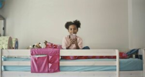 Mädchen sitzt mit Smartphone im Bett. Die Displayzeit sollte nicht nach Stunden begrenzt sein, sondern klar, für alle einhaltbare regeln verfolgen. Bild: bruce-mars-p4e4y4J7H4k-unsplash