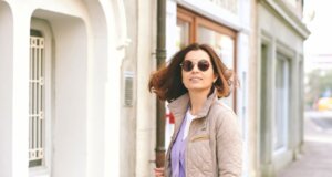 Wenn es noch nicht ganz Frühling it, aber ein bisschen. Dann ist der Lagenlook mit Pastellefareben schön und praktisch. Auf die Bild sieht man eine Freu mittleren Alters in Steppjacke in beige mit flieder farbendem Cardigan darunter.