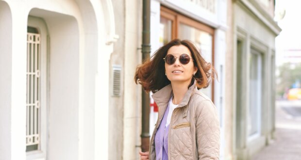 Wenn es noch nicht ganz Frühling it, aber ein bisschen. Dann ist der Lagenlook mit Pastellefareben schön und praktisch. Auf die Bild sieht man eine Freu mittleren Alters in Steppjacke in beige mit flieder farbendem Cardigan darunter.