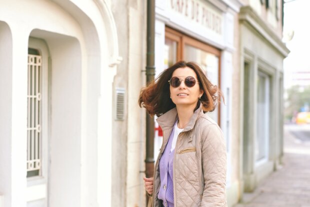 Wenn es noch nicht ganz Frühling it, aber ein bisschen. Dann ist der Lagenlook mit Pastellefareben schön und praktisch. Auf die Bild sieht man eine Freu mittleren Alters in Steppjacke in beige mit flieder farbendem Cardigan darunter.