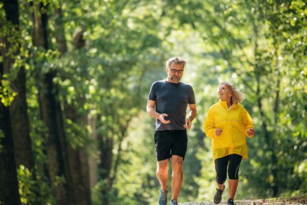 Zwei Menschen über 50 beim Joggen in schöner grüner Umgebung. Gesundheitsvorsorge ab 50 ist wichtig. Bild: iStock-2180466138-standret